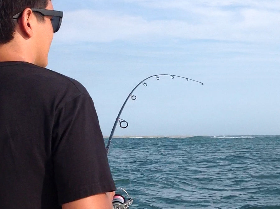 Young man reeling in fish