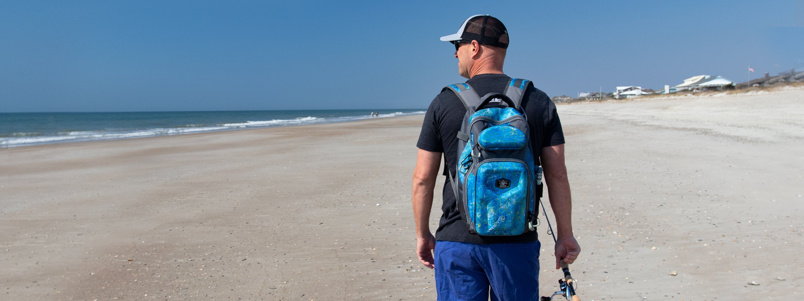 Fisherman on beach with Calcutta tackle backpack