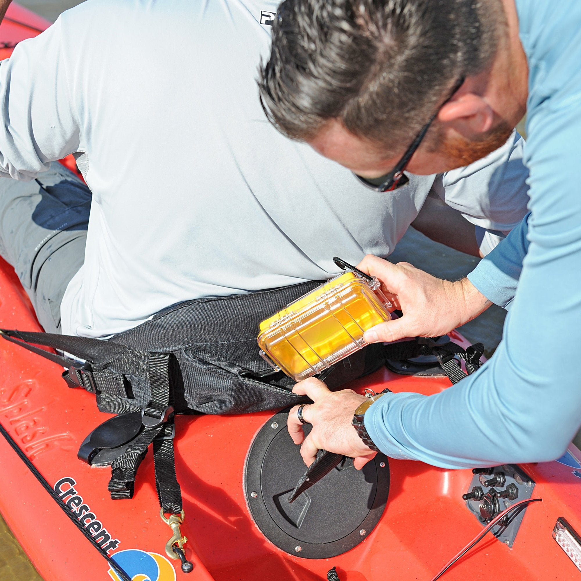 Kayaker storing gear in deck plate