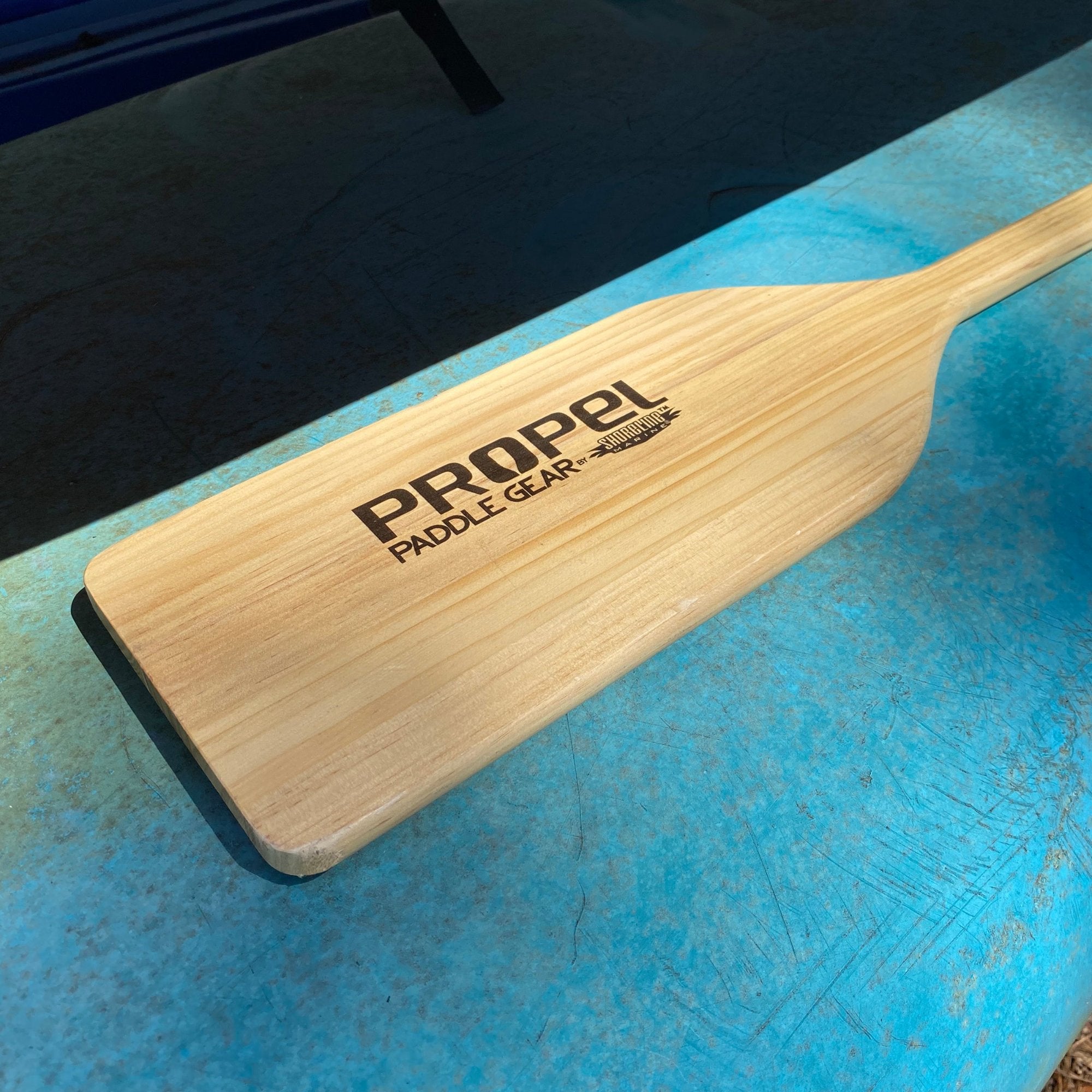 Propel wooden paddle on canoe bottom