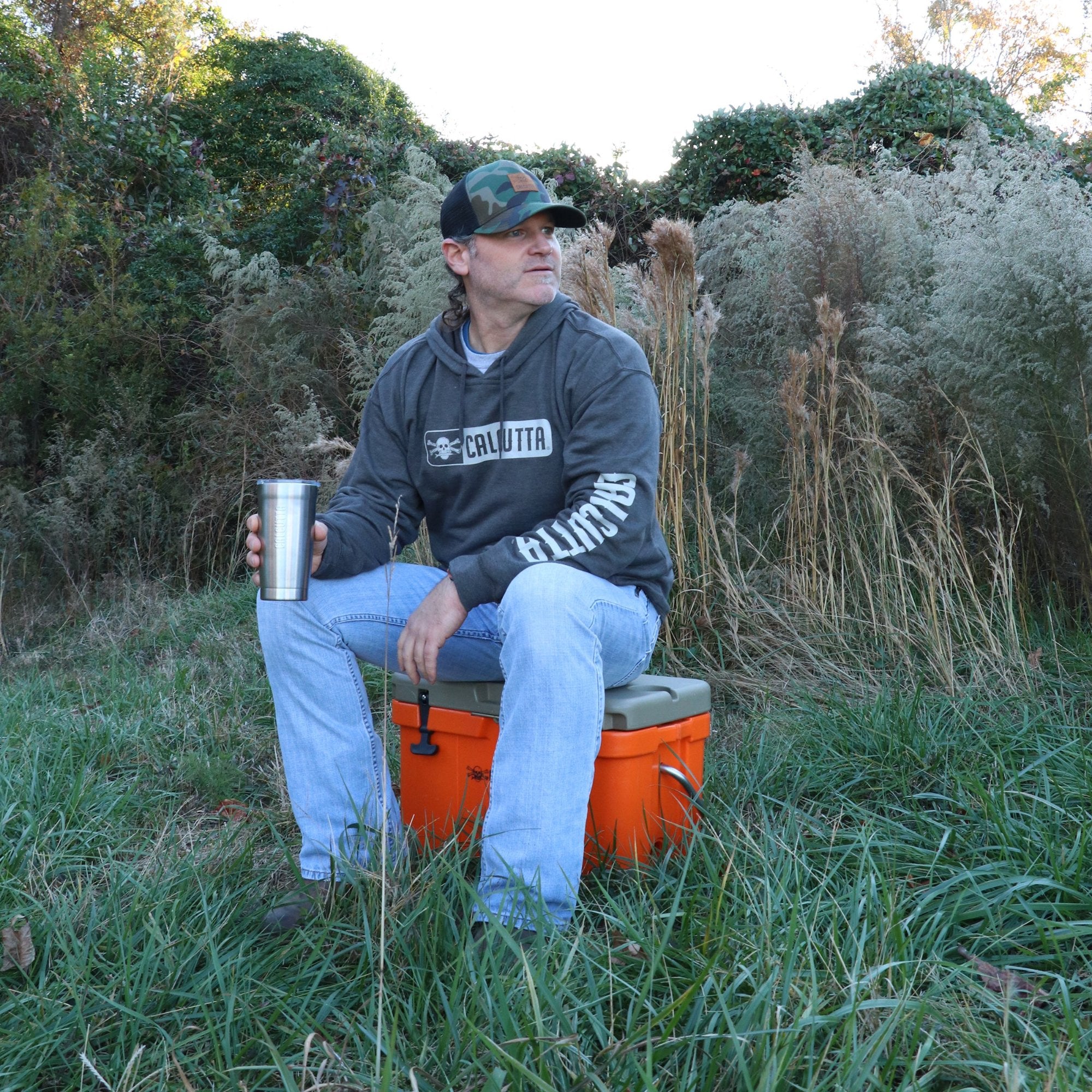 Outdoorsman with Calcutta sweatshirt and tumbler